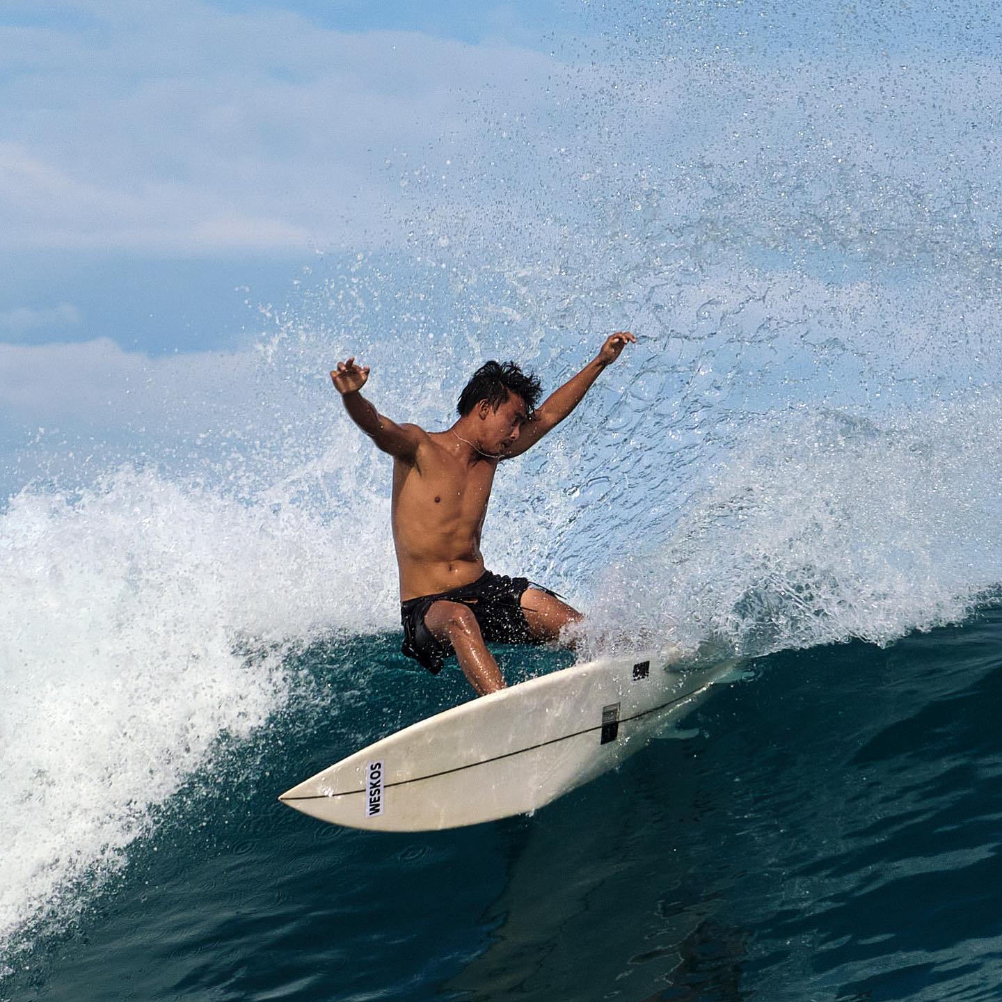 Surfer carving a turn on a Krui wave